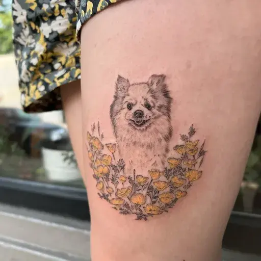 fine line pomeranian tattoo with yellow poppies on thigh