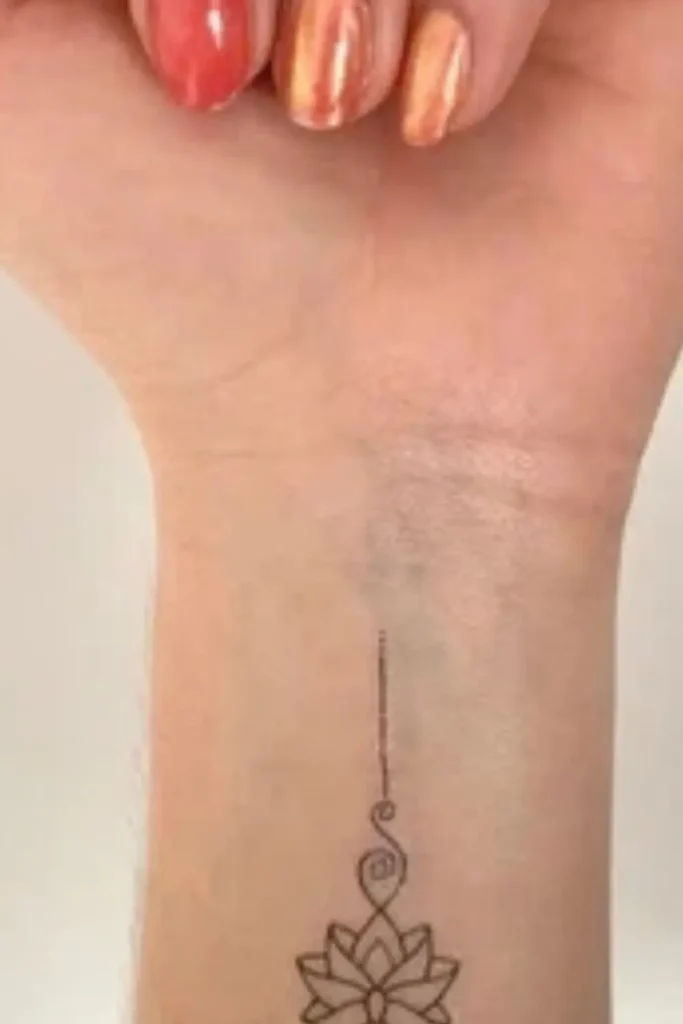 minimalist lotus unalome tattoo on the inner wrist